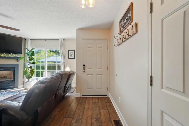 5688 Blendonridge Dr Unit 93E, Columbus, OH 43230 - interior space featuring a textured ceiling, a glass covered fireplace, baseboards, dark wood-type flooring, and visible vents