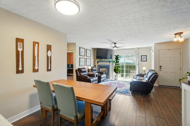 5688 Blendonridge Dr Unit 93E, Columbus, OH 43230 - dining room with a ceiling fan, a textured ceiling, dark wood finished floors, baseboards, and a glass covered fireplace
