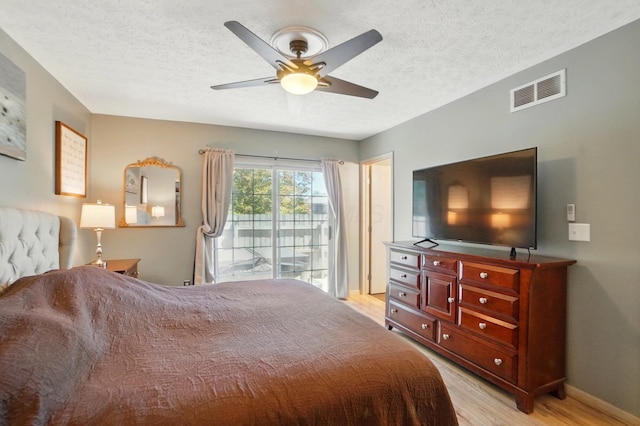 5688 Blendonridge Dr Unit 93E, Columbus, OH 43230 - bedroom featuring ceiling fan, a textured ceiling, access to exterior, light wood-style flooring, and visible vents