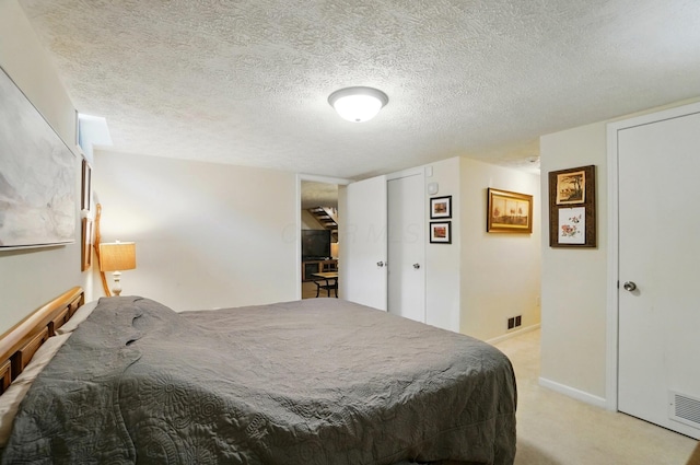 5688 Blendonridge Dr Unit 93E, Columbus, OH 43230 - bedroom featuring a textured ceiling, visible vents, light carpet, and baseboards