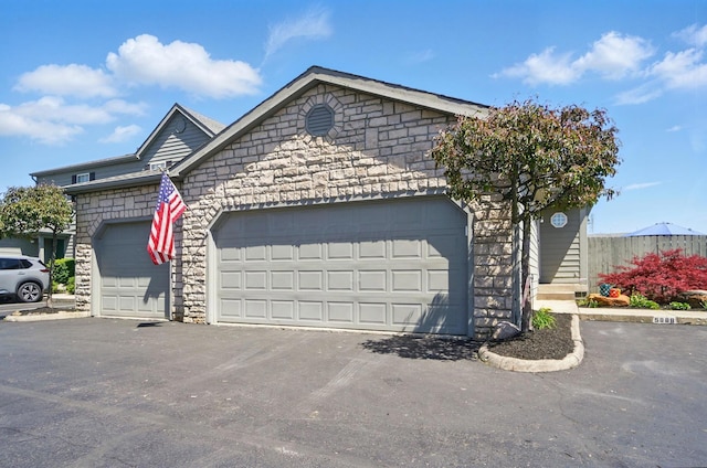 5688 Blendonridge Dr Unit 93E, Columbus, OH 43230 - view of front of property featuring a garage, aphalt driveway, and stone siding