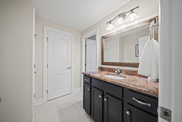 bathroom featuring tile patterned floors, baseboards, and vanity