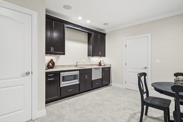 kitchen with a sink, stainless steel microwave, dishwashing machine, ornamental molding, and light carpet