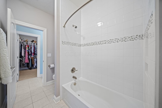 full bathroom featuring tub / shower combination, toilet, baseboards, a walk in closet, and tile patterned floors