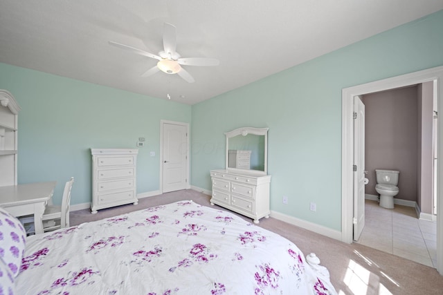 carpeted bedroom featuring baseboards, ceiling fan, and ensuite bath