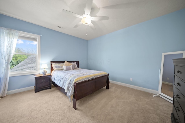 bedroom with visible vents, baseboards, ceiling fan, and light carpet