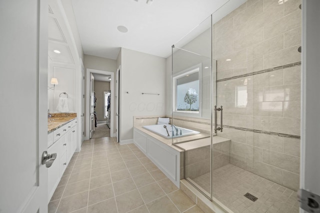 bathroom with tile patterned flooring, vanity, a bath, and a shower stall