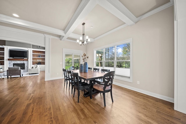 dining space featuring baseboards, a notable chandelier, beam ceiling, and wood finished floors