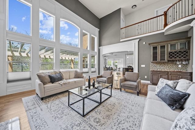 living area with indoor bar, a high ceiling, and wood finished floors