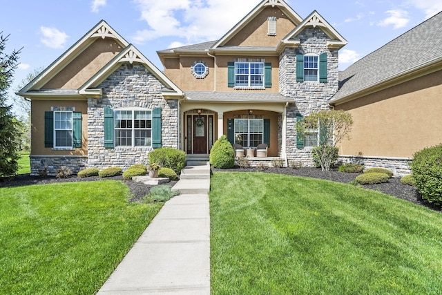 craftsman-style home with a front lawn, stone siding, and stucco siding