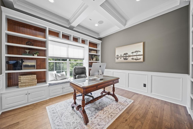 home office featuring crown molding, beam ceiling, light wood finished floors, a wainscoted wall, and coffered ceiling