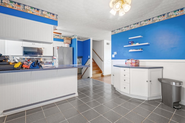 14 Stoney Ridge Dr SW, Pataskala, OH 43062 - kitchen featuring dark countertops, appliances with stainless steel finishes, a textured ceiling, and white cabinetry