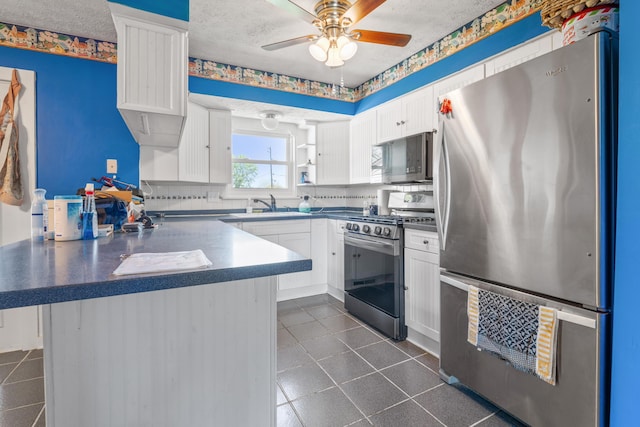 14 Stoney Ridge Dr SW, Pataskala, OH 43062 - kitchen featuring a peninsula, dark countertops, ceiling fan, white cabinets, and stainless steel appliances