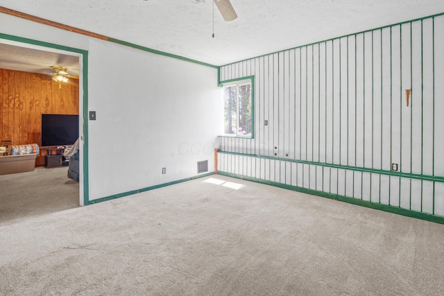 14 Stoney Ridge Dr SW, Pataskala, OH 43062 - carpeted spare room with a ceiling fan, a textured ceiling, visible vents, and wood walls