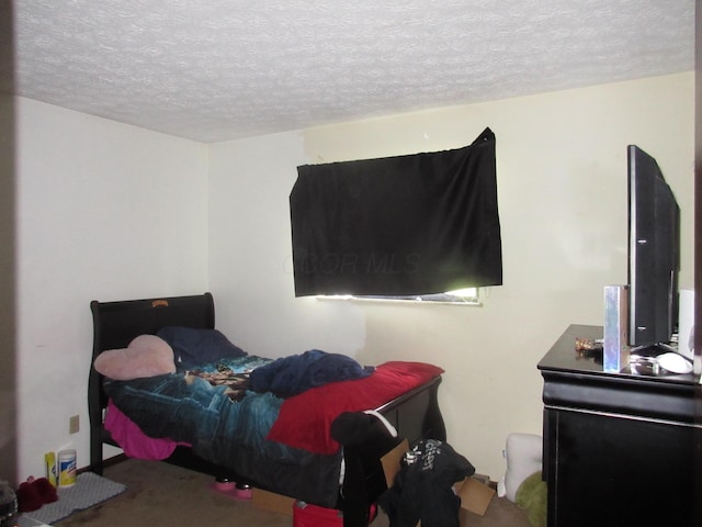 bedroom with a textured ceiling and carpet floors