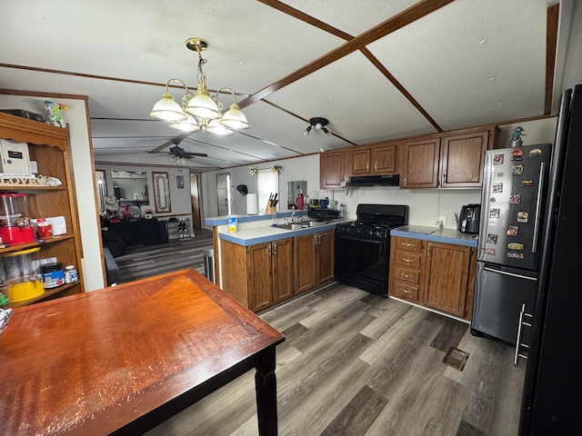 1049 Harmon Ave Unit C82, Columbus, OH 43223 - kitchen with under cabinet range hood, ceiling fan, a peninsula, black gas range oven, and freestanding refrigerator