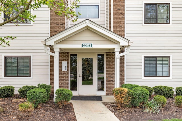 property entrance with brick siding and french doors