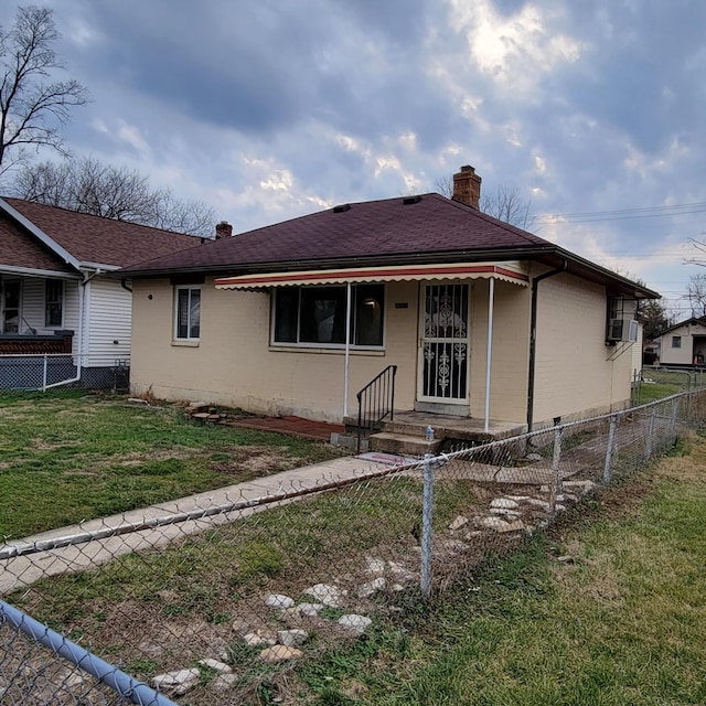 4053 Delphos Ave, Dayton, OH 45402 - back of property featuring a shingled roof, a fenced front yard, a yard, a chimney, and brick siding
