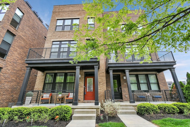 754 N 6th St, Columbus, OH 43215 - view of front of house featuring brick siding, a balcony, and covered porch