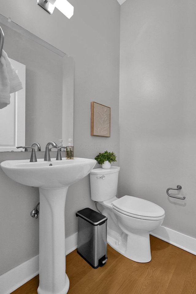 754 N 6th St, Columbus, OH 43215 - half bathroom featuring toilet, baseboards, and wood finished floors