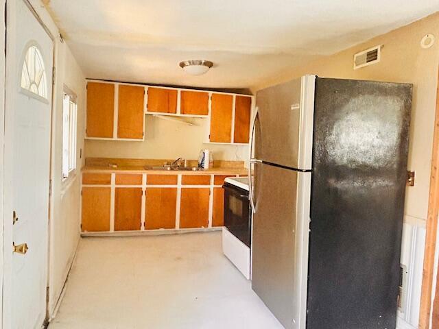 485 Union Ave, Buckeye Lake, OH 43008 - kitchen featuring electric stove, a sink, brown cabinets, visible vents, and freestanding refrigerator