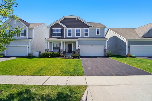 craftsman-style home featuring a porch, aphalt driveway, a front lawn, an attached garage, and stone siding