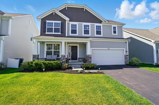 craftsman-style home with a porch, an attached garage, driveway, and a front yard