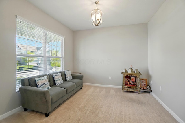 living area with light colored carpet, baseboards, and a notable chandelier
