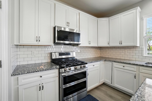 kitchen featuring wood finished floors, white cabinets, light stone countertops, and stainless steel appliances