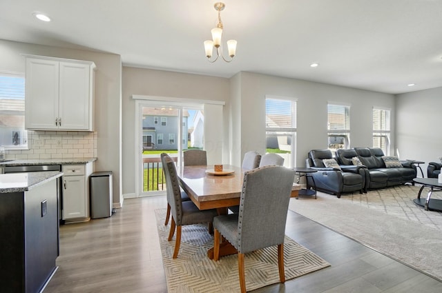 dining room with recessed lighting, a chandelier, and light wood-type flooring