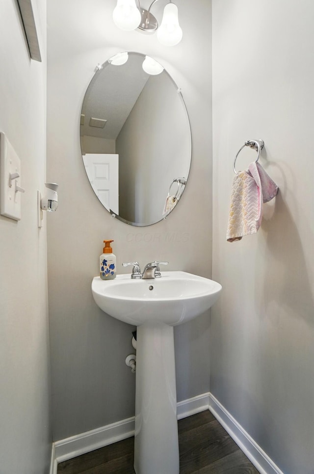 bathroom with baseboards and wood finished floors