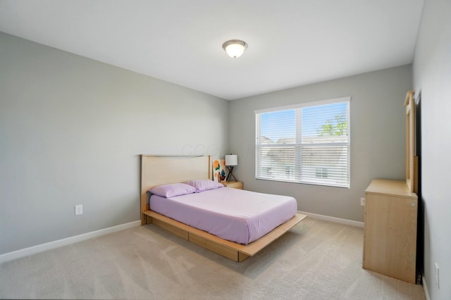 bedroom with baseboards and light carpet