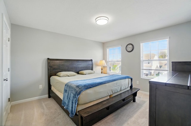 bedroom with baseboards and light colored carpet