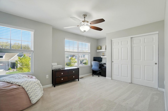 carpeted bedroom featuring a closet, baseboards, and ceiling fan