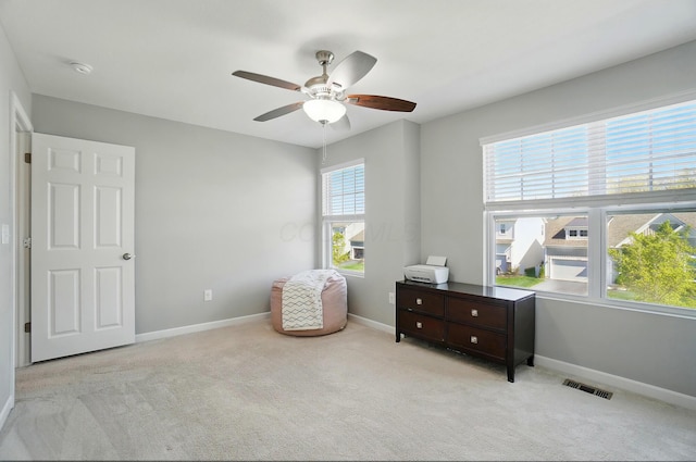 sitting room with baseboards, a ceiling fan, and carpet