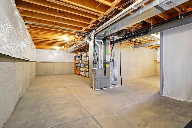 unfinished below grade area featuring heating unit and gas water heater