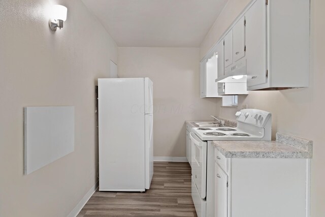 kitchen featuring wood finished floors, white appliances, under cabinet range hood, light countertops, and baseboards