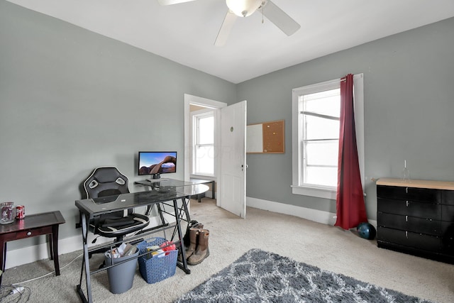 carpeted home office featuring ceiling fan and baseboards