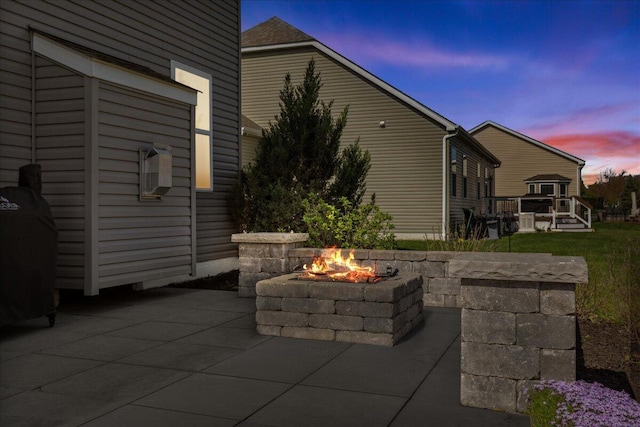 patio terrace at dusk featuring an outdoor fire pit