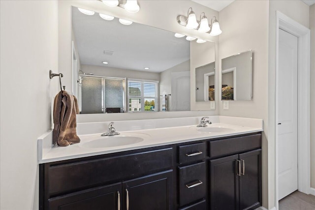 full bath with a sink, tile patterned flooring, a shower stall, and double vanity