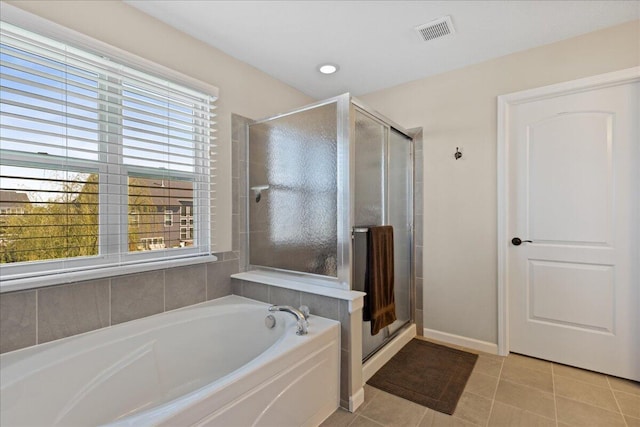 bathroom featuring plenty of natural light, a shower stall, a bath, and visible vents