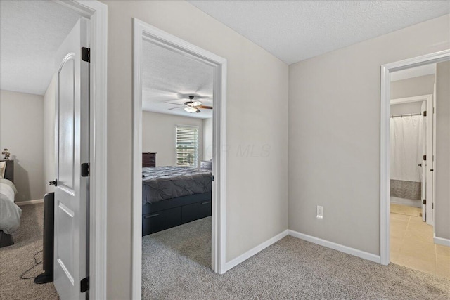 bedroom featuring baseboards, carpet flooring, a textured ceiling, and a ceiling fan