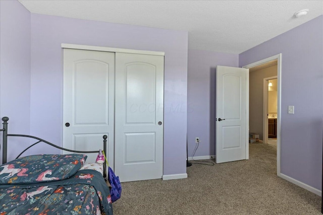 carpeted bedroom with baseboards and a closet