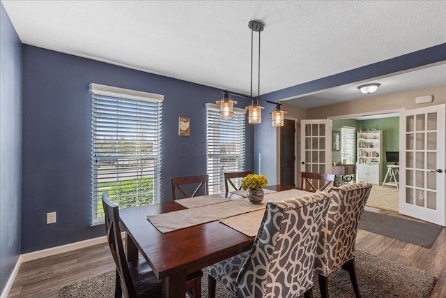 dining room with a textured ceiling, baseboards, french doors, and wood finished floors