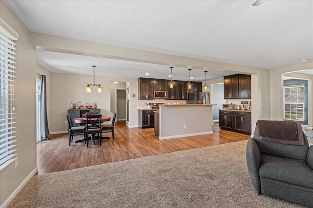 living room featuring baseboards, wood finished floors, and a chandelier