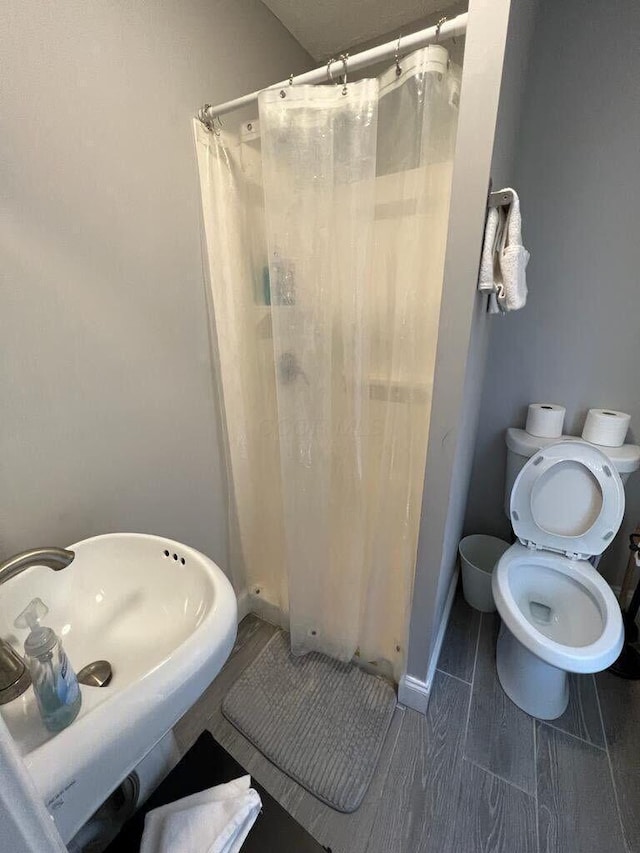 full bath with a sink, a stall shower, and toilet