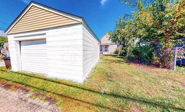 view of side of property with a garage, an outbuilding, and a yard