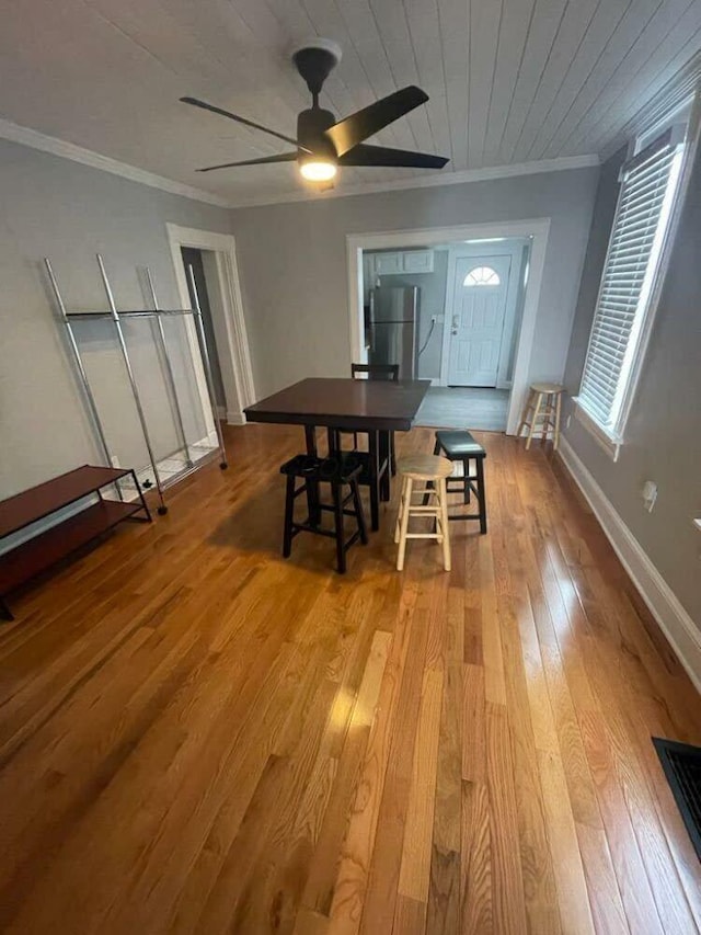 dining room featuring crown molding, ceiling fan, baseboards, and hardwood / wood-style floors