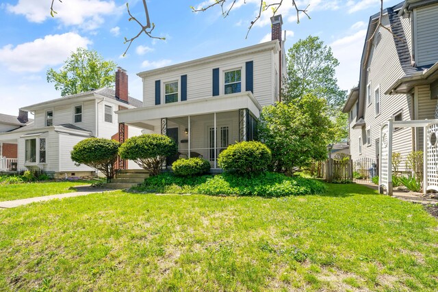 view of front of home with fence, a chimney, and a front yard