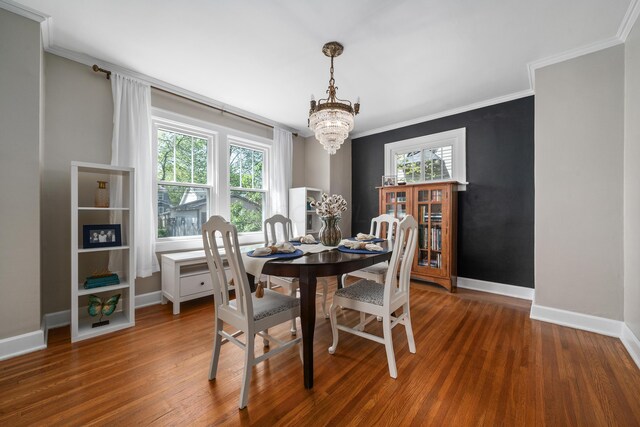 dining room featuring baseboards, an inviting chandelier, ornamental molding, and wood finished floors